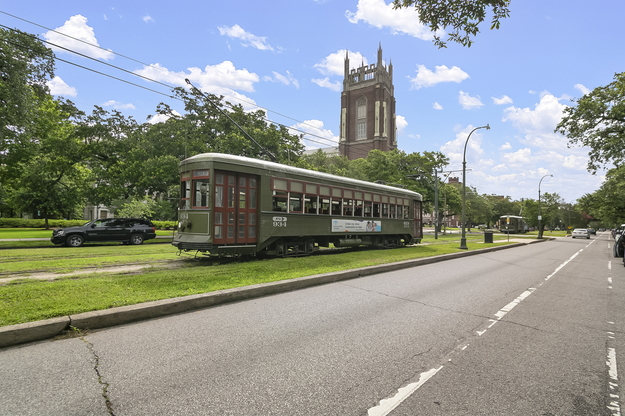 The historic green streetcar rolling along the oak-lined avenue near Audubon and the universities